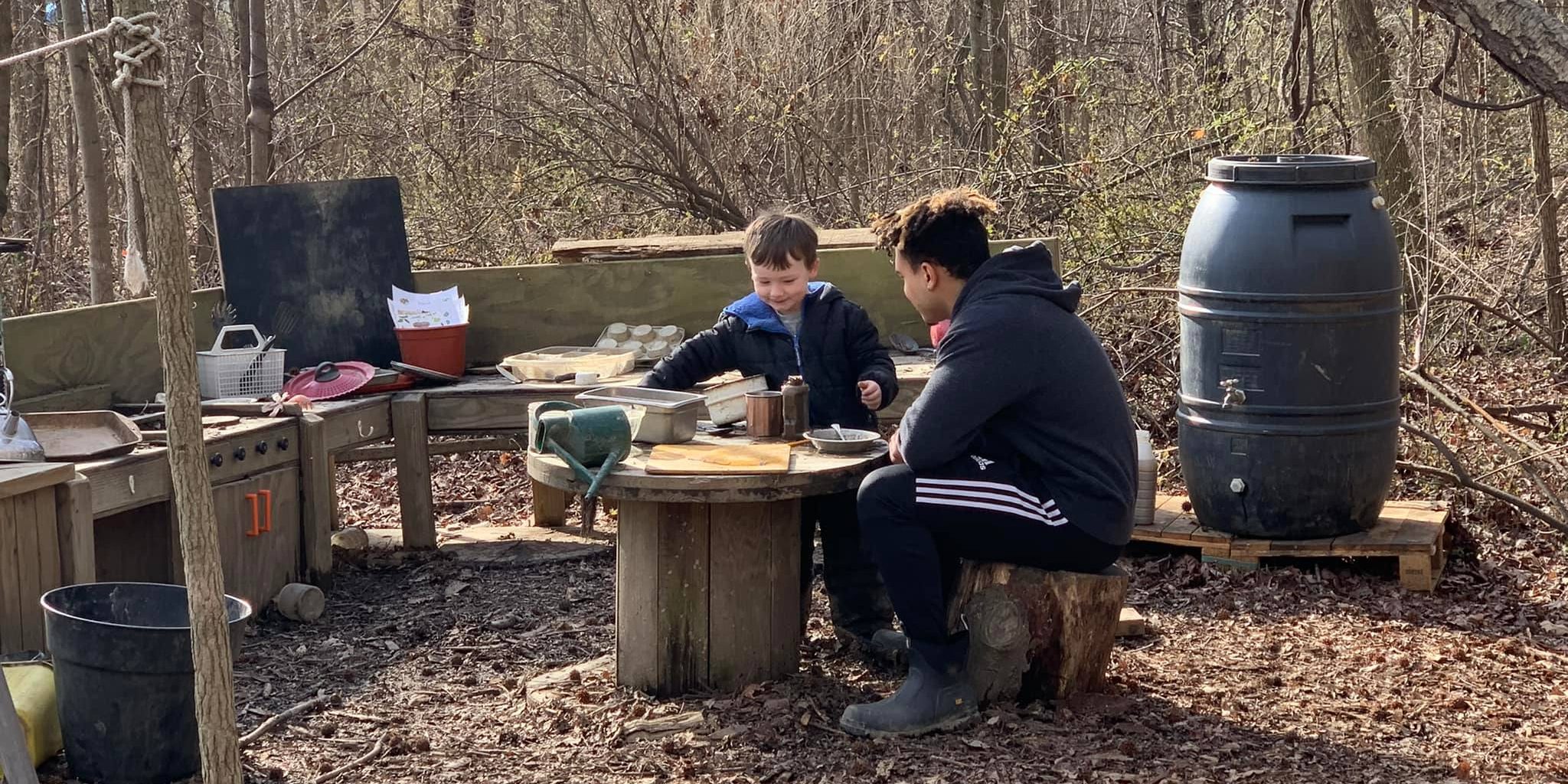 A University of Delaware student and a child interact in the Lab’s School’s outdoor mud kitchen, located on the College of Education and Human Development’s Children’s Campus.